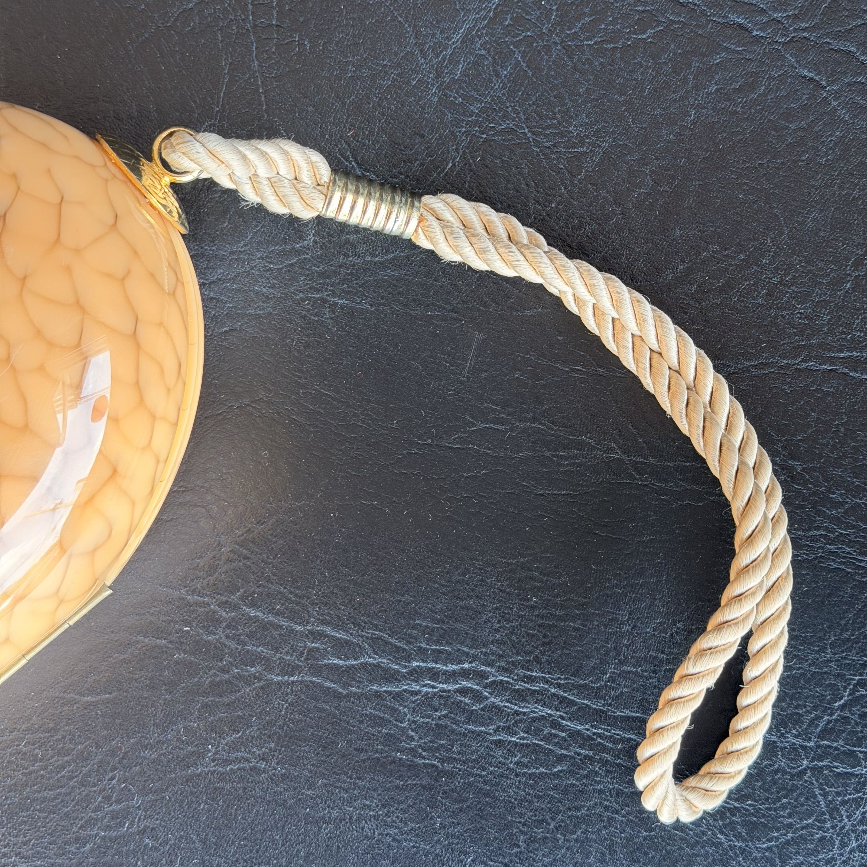 Rope attached to a woven basket on a dark leather surface