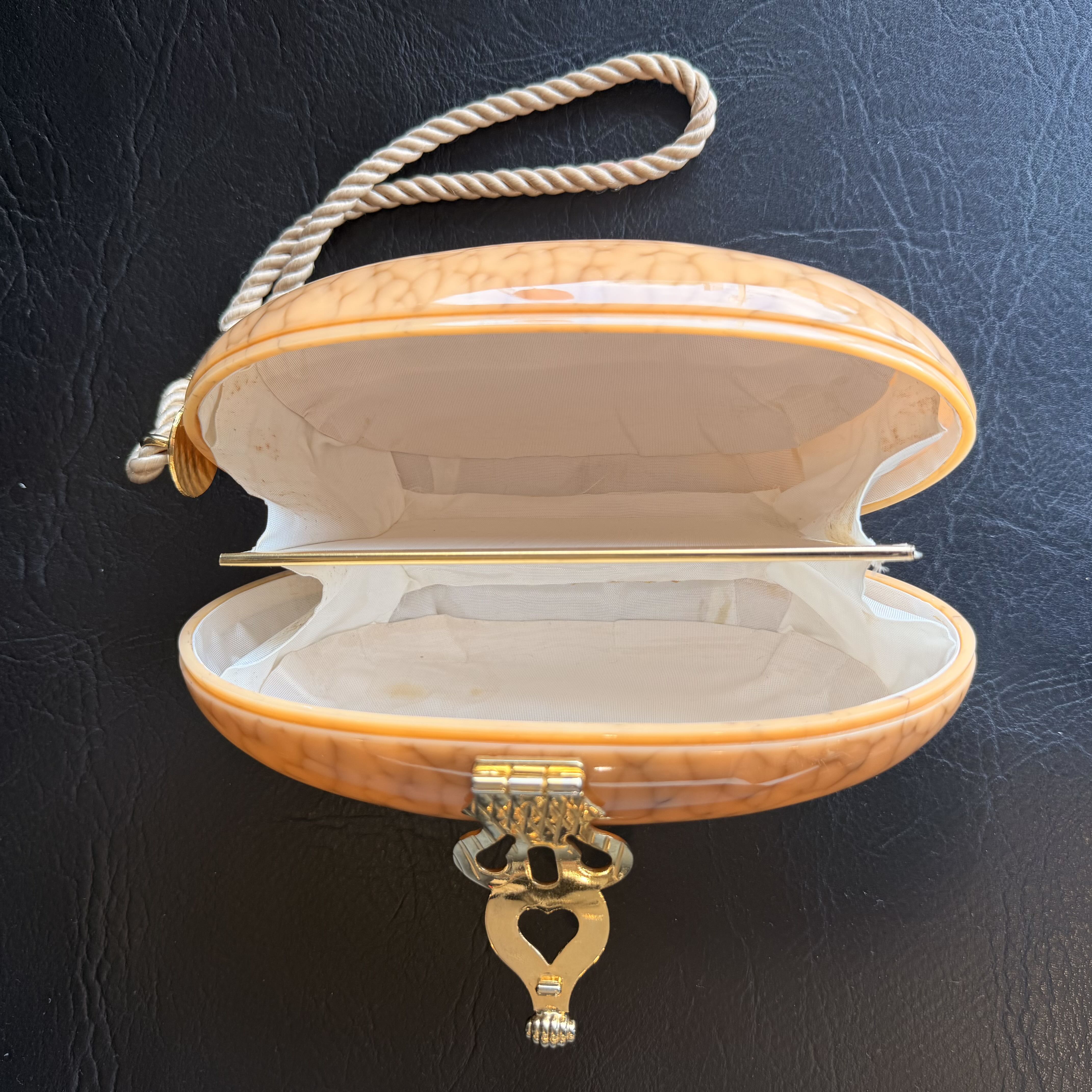 Open jewelry box with decorative clasp on a dark textured background
