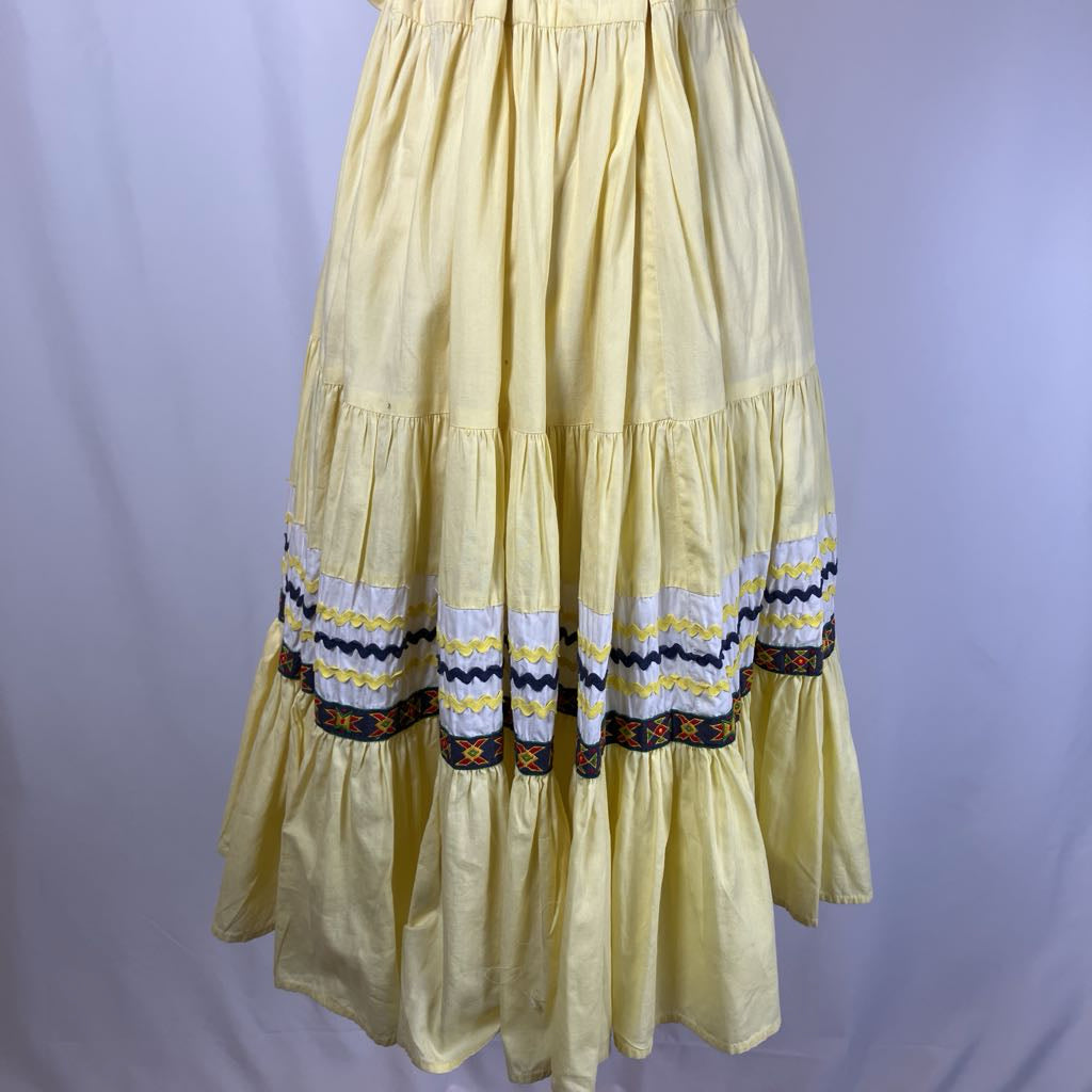 Yellow dress with decorative hem on a plain background