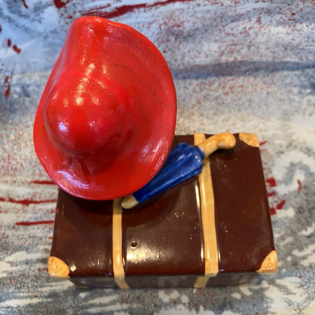 Decorative item with a red hat and blue object on a textured surface
