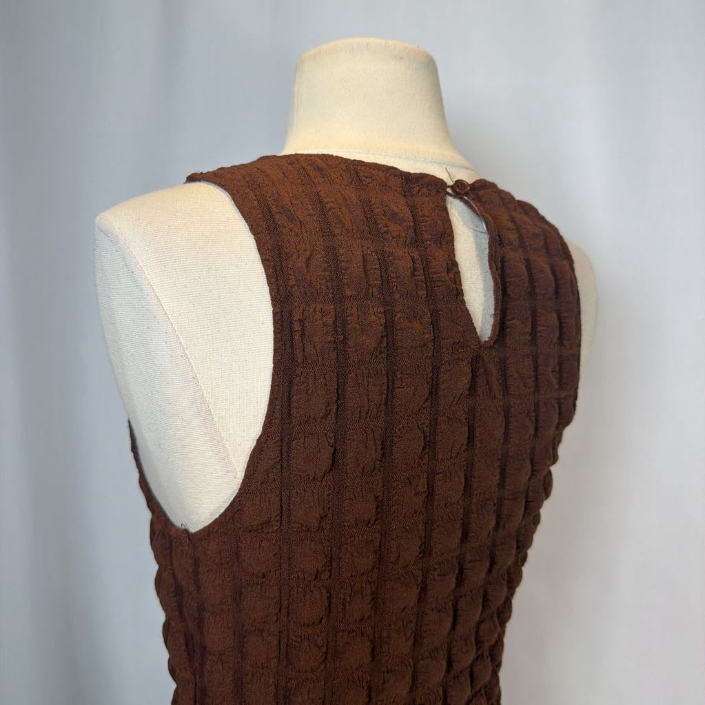 Brown textured dress on a mannequin against a plain background