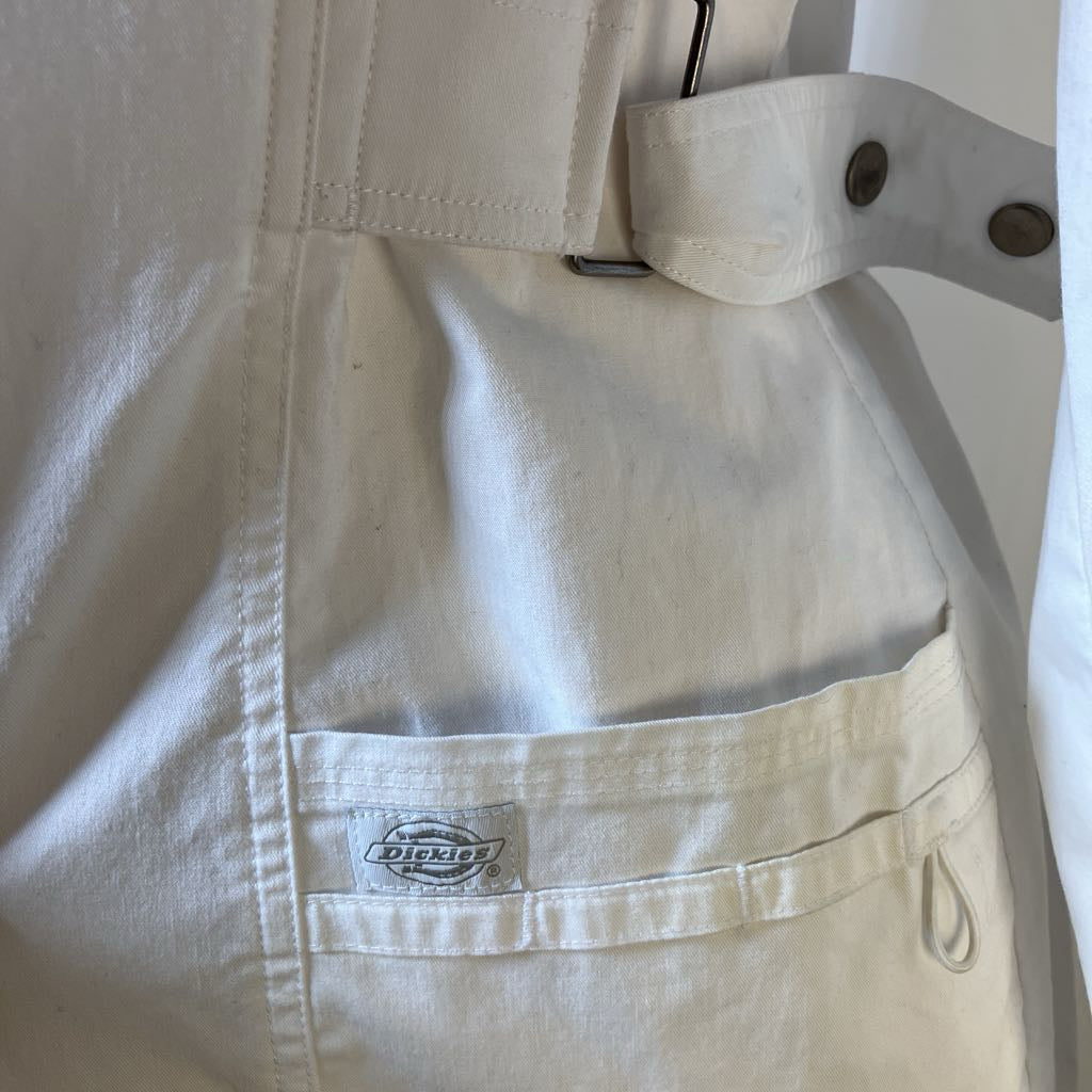 Beige jacket with a Dickies logo on the chest pocket against a white background