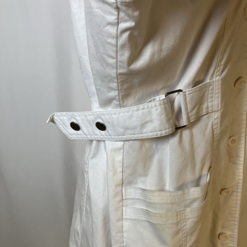 Close-up of a beige jacket with a pocket and button details on a light gray background