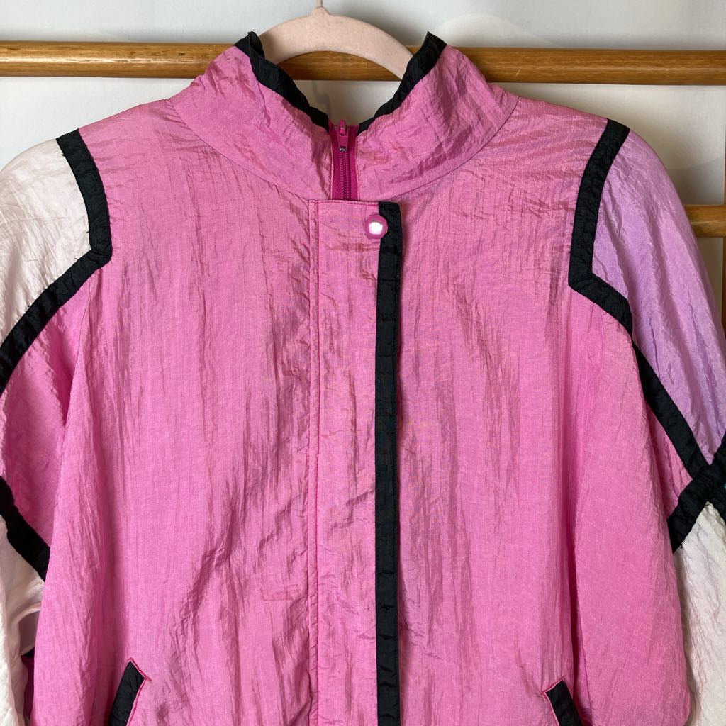 Pink jacket with black accents on a wooden hanger
