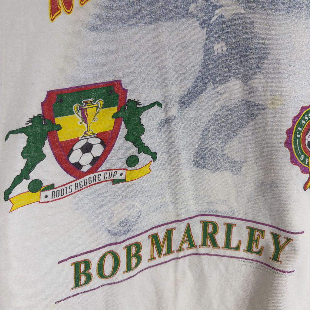T-shirt with Bob Marley branding and sports-themed graphics on a white background