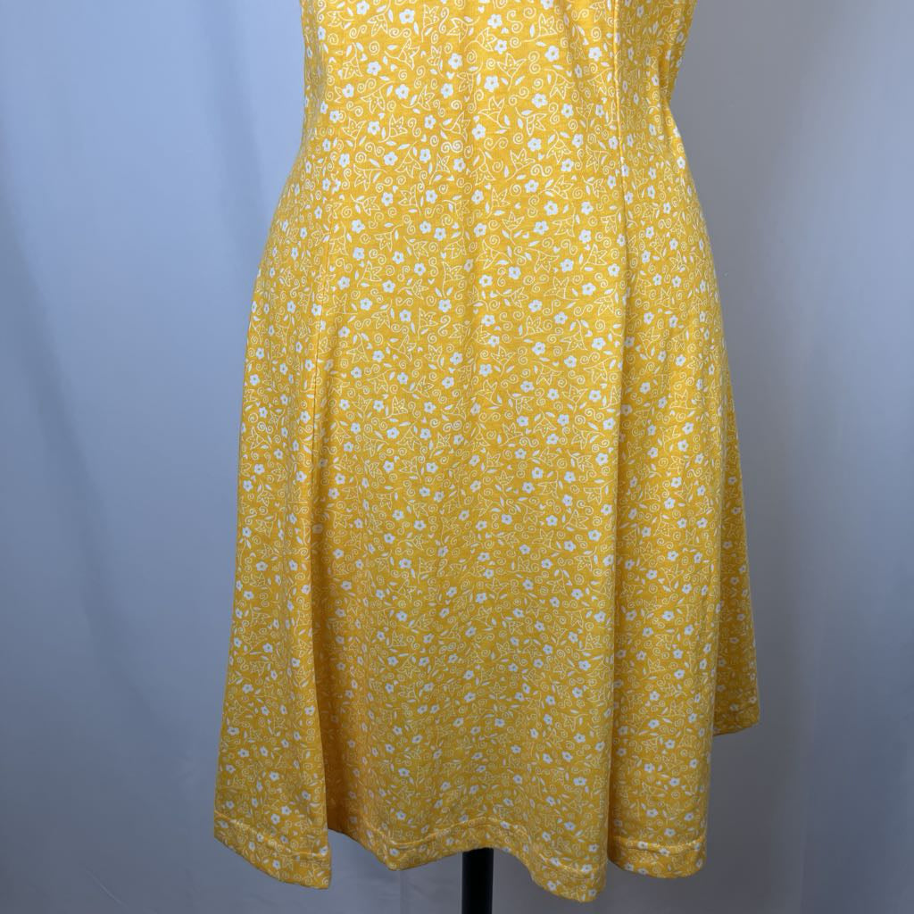 Yellow dress with white floral pattern on a gray background