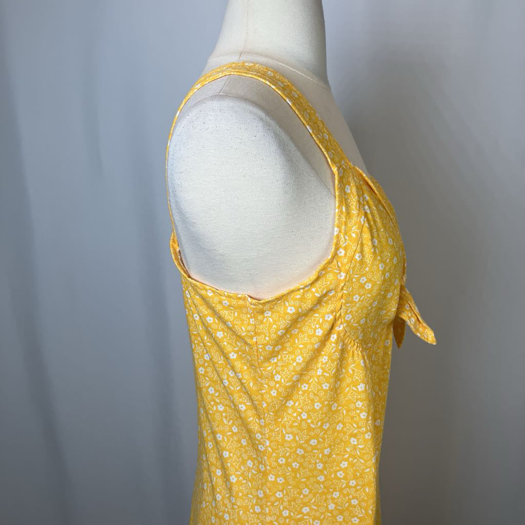 Yellow floral dress on a mannequin against a gray background