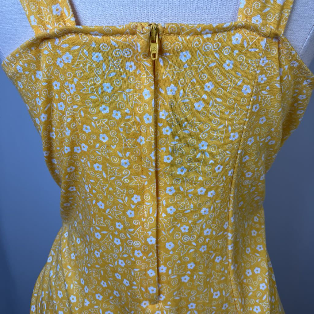 Yellow floral dress on a mannequin against a blue background