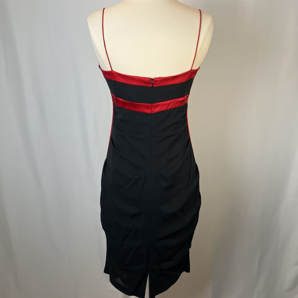 Black dress with red accents on a mannequin against a plain background