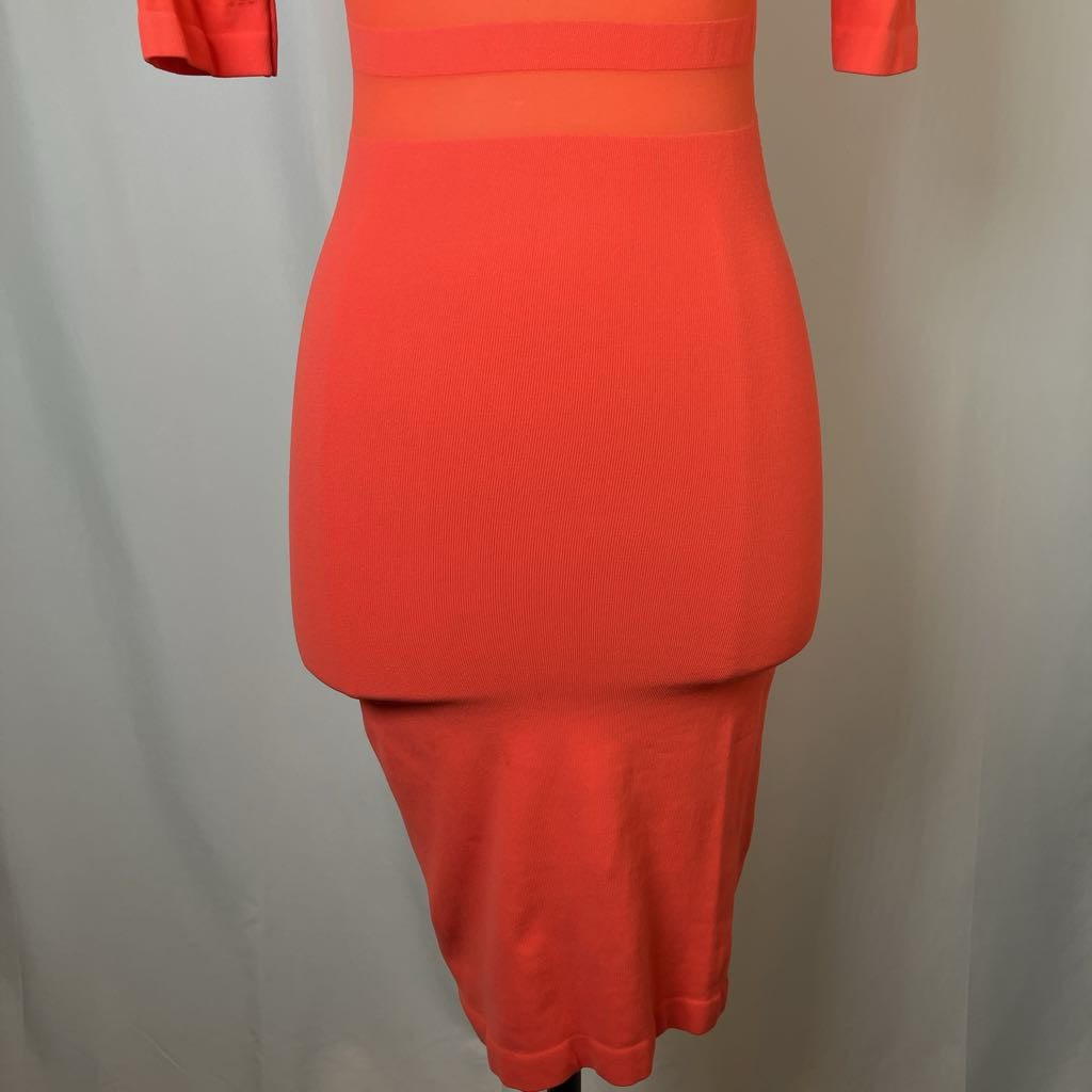 Orange dress on a mannequin against a plain background