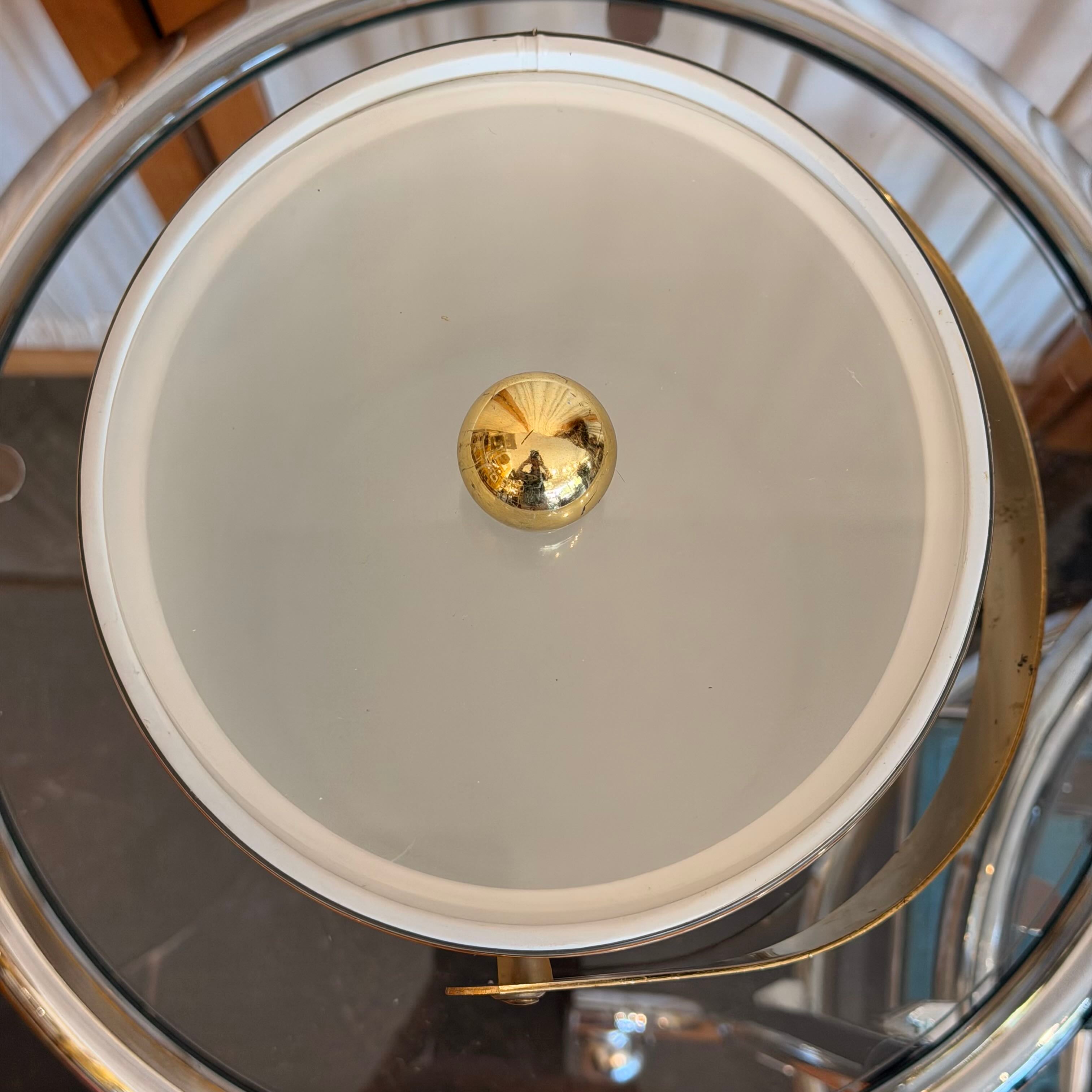 Glass lid with a gold knob on a metallic surface