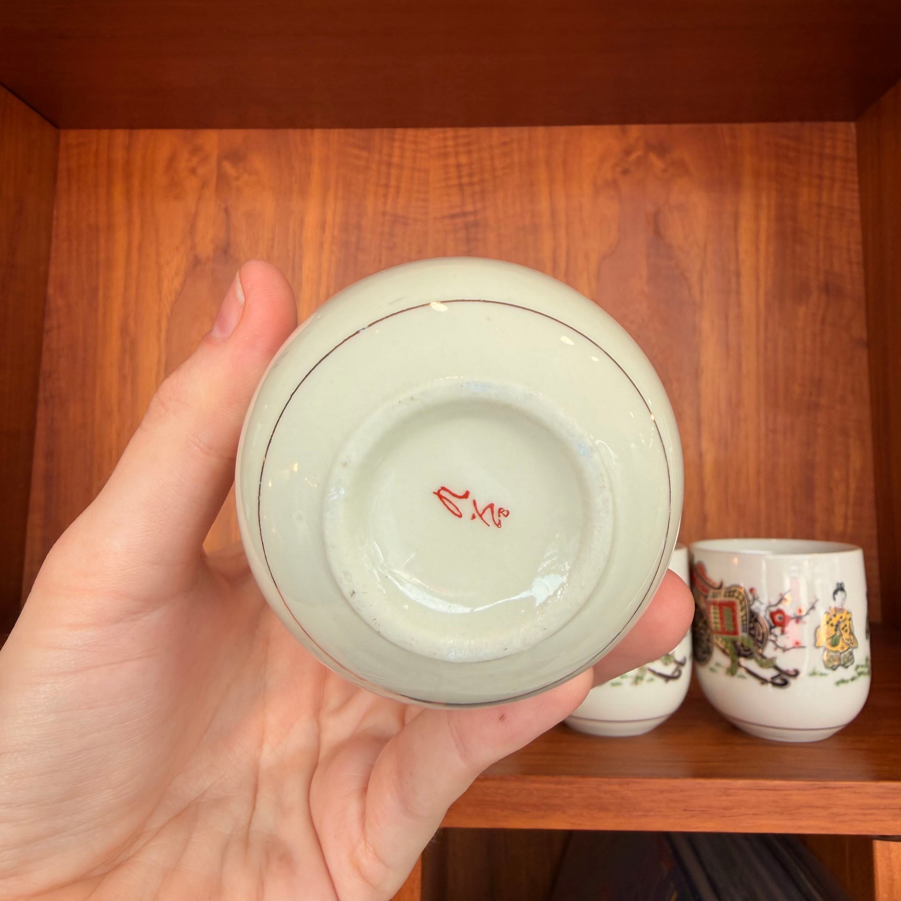 botom of cup being held by a hand against a wooden background showing a logo 