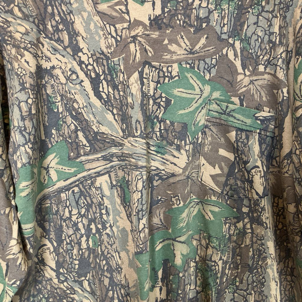 Close-up of a camouflage fabric with green, brown, and beige patterns.