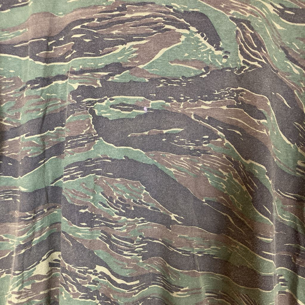 Close-up of camouflage fabric with green, brown, and black pattern