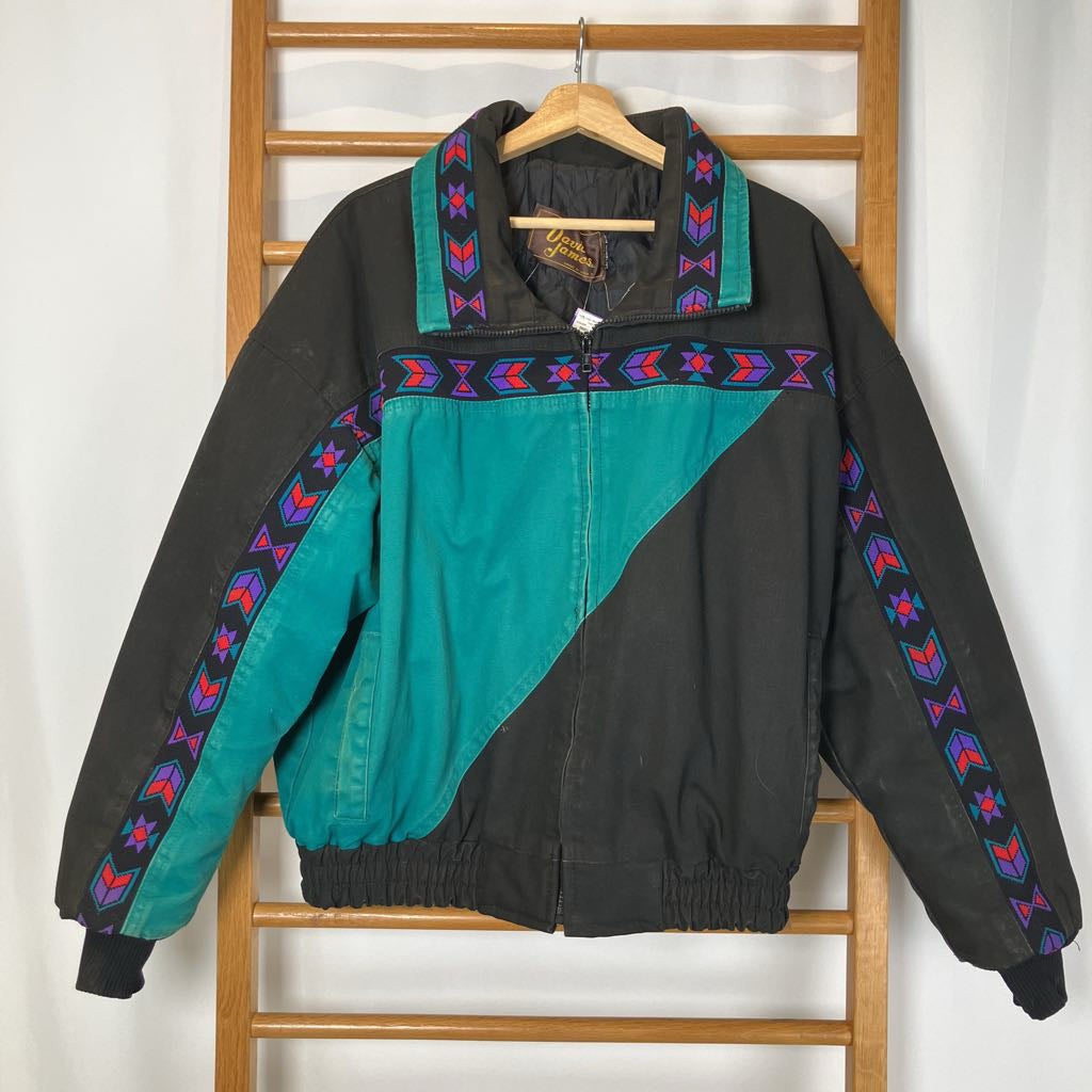 Black and teal jacket with colorful patterns on a wooden rack against a white wall