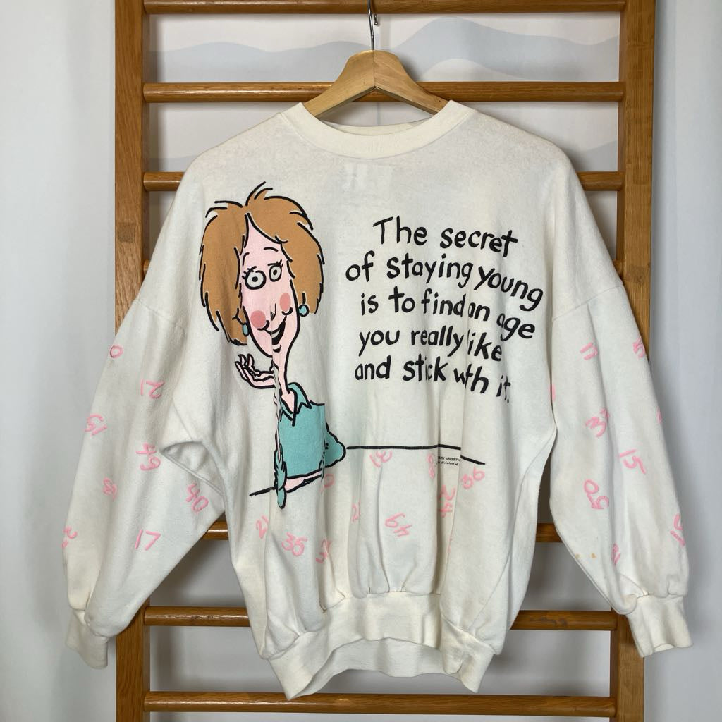 Sweatshirt with cartoon character and text on a wooden rack