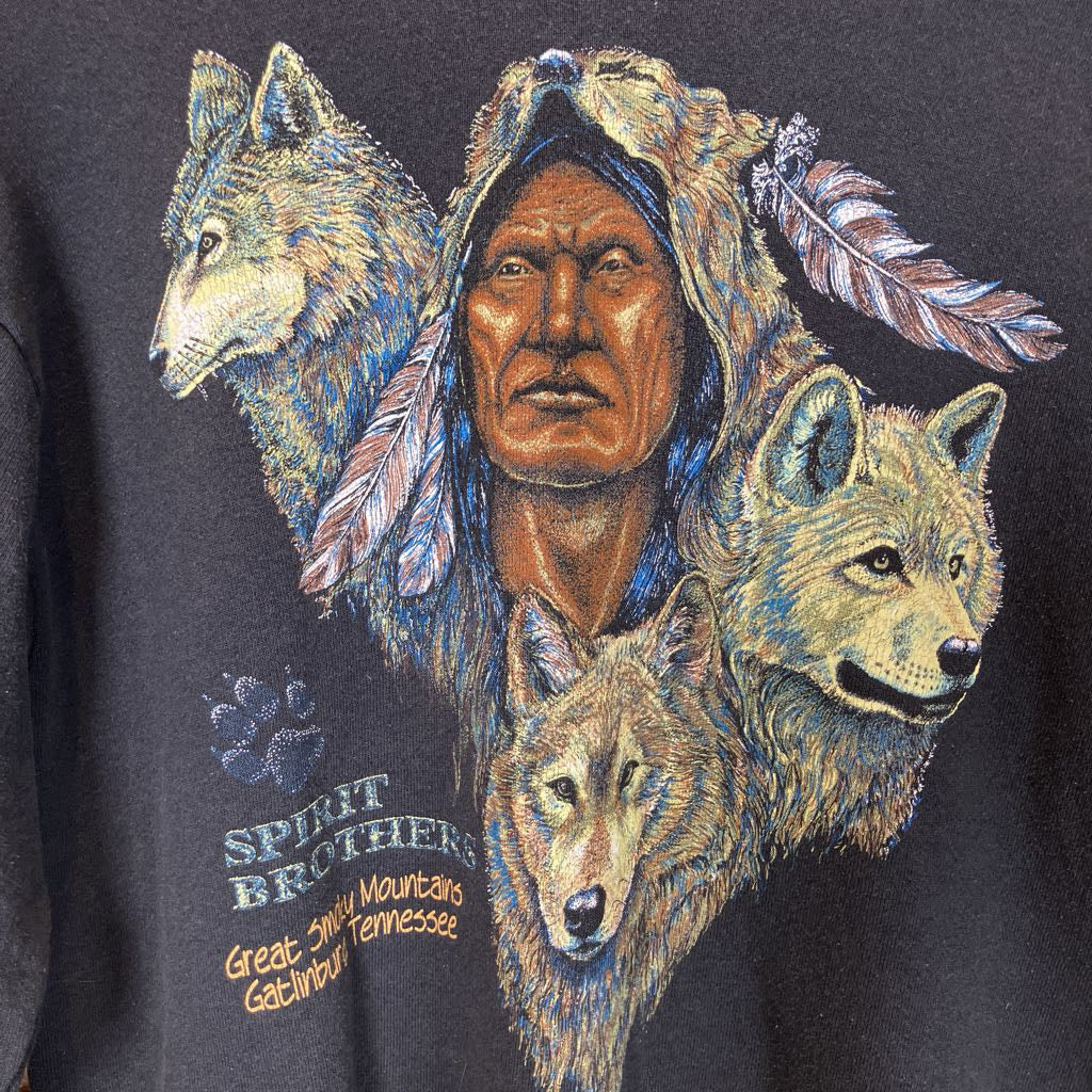 Black sweatshirt with a graphic of a Native American and wolves on a wooden rack.
