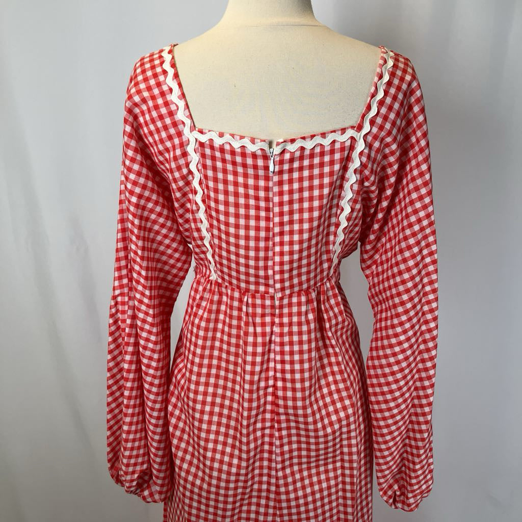 Red and white checkered dress on a mannequin against a plain background