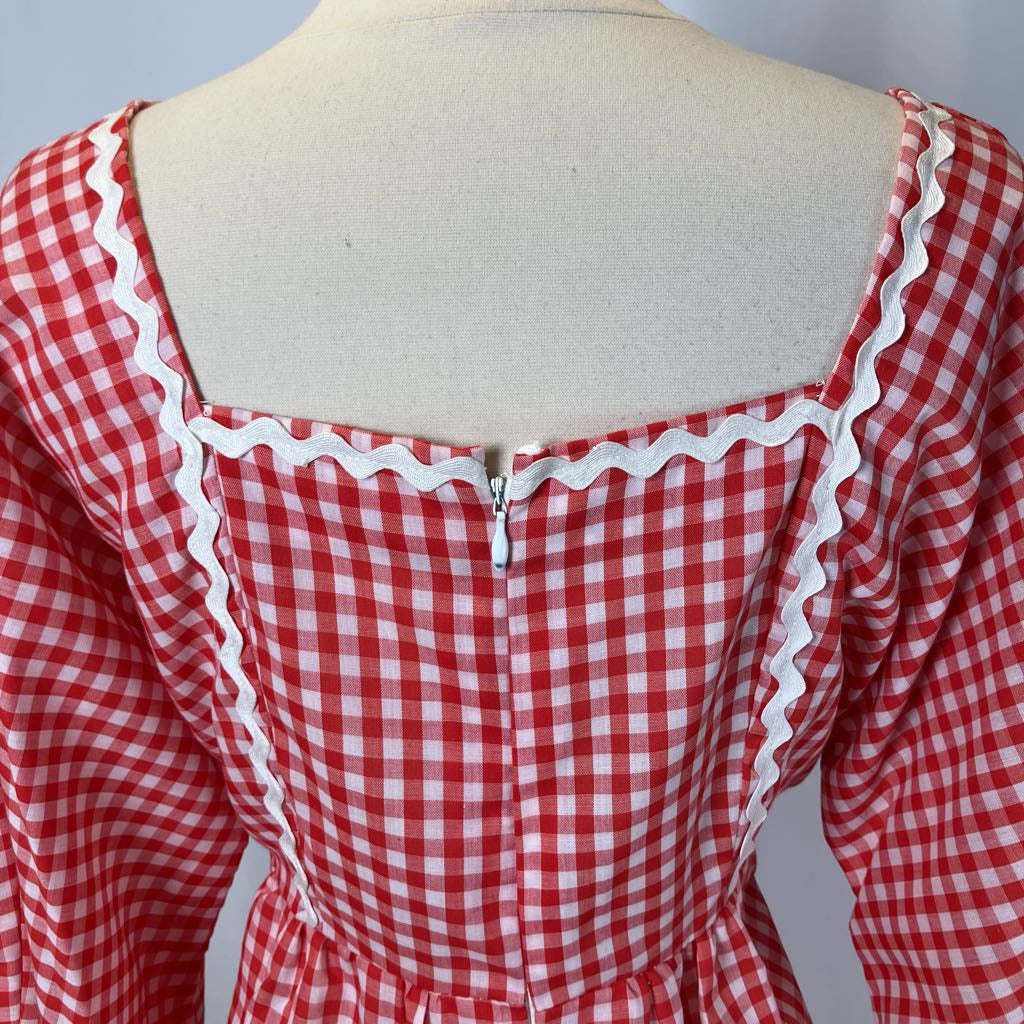 Red and white checkered dress on a mannequin with a plain background
