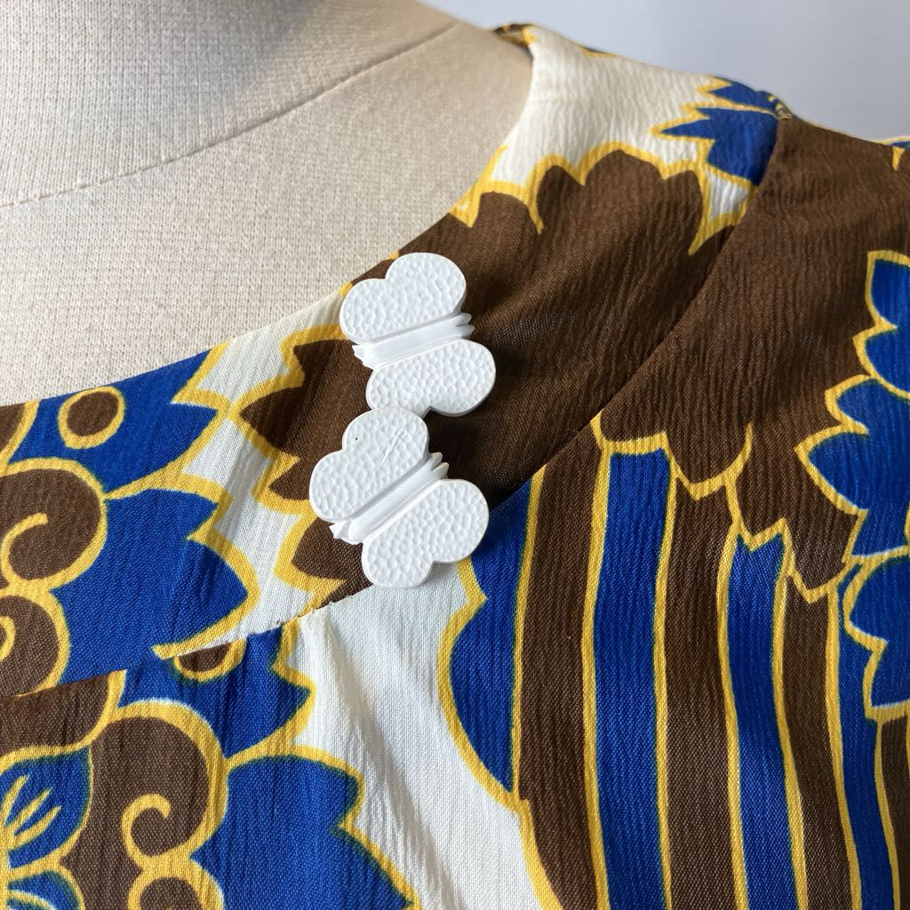 Close-up of a garment with blue, brown, and white floral pattern on a mannequin.