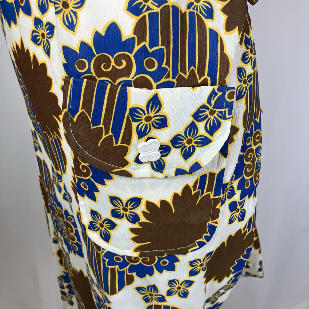 Close-up of a patterned fabric with blue and brown floral design on a white background