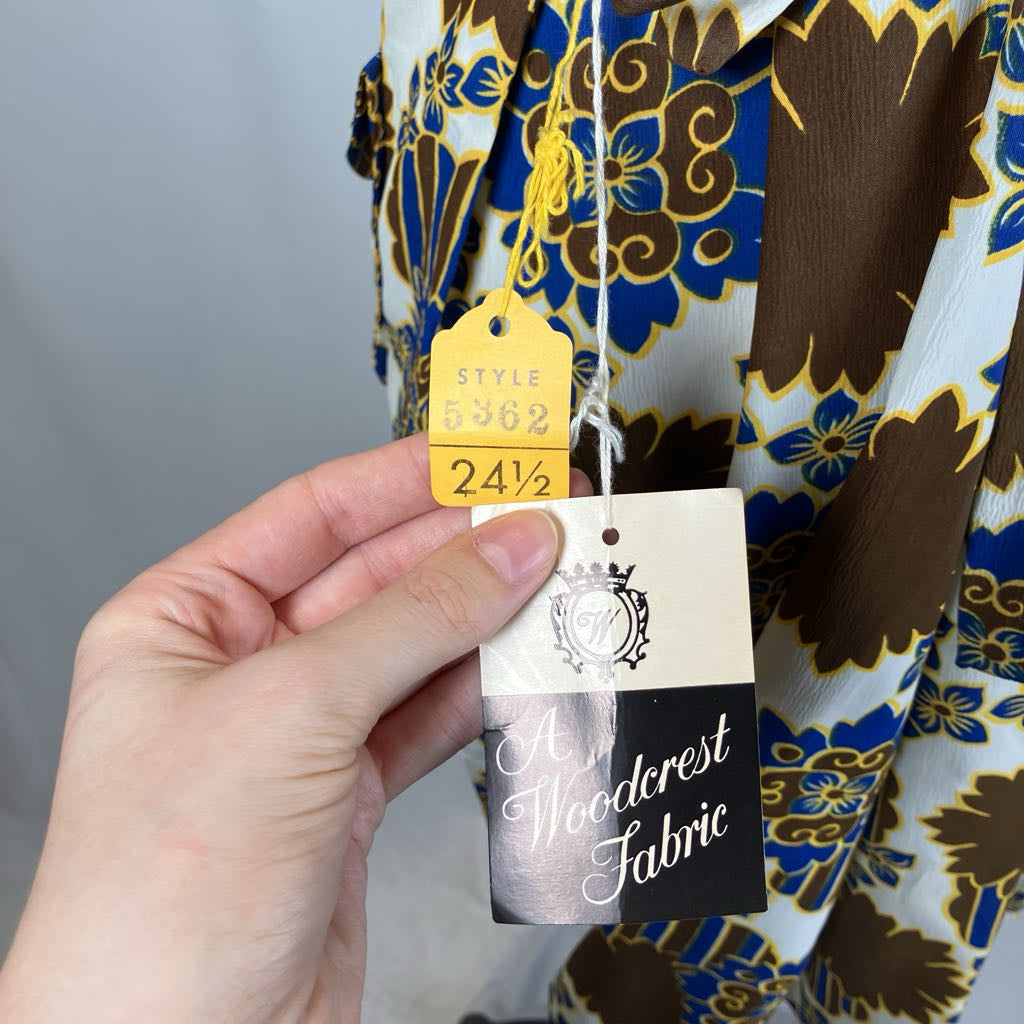 Hand holding a fabric tag with a patterned fabric background