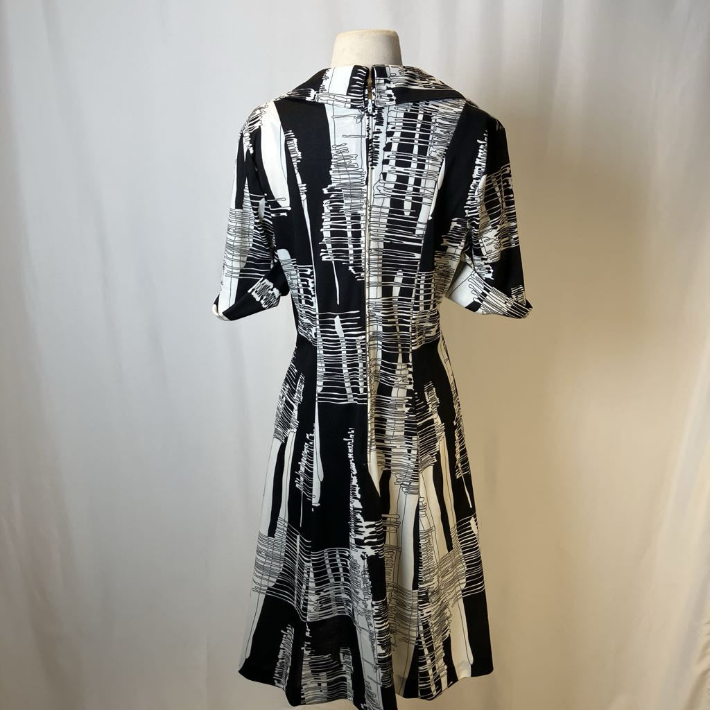 Black and white patterned dress on a mannequin against a plain background