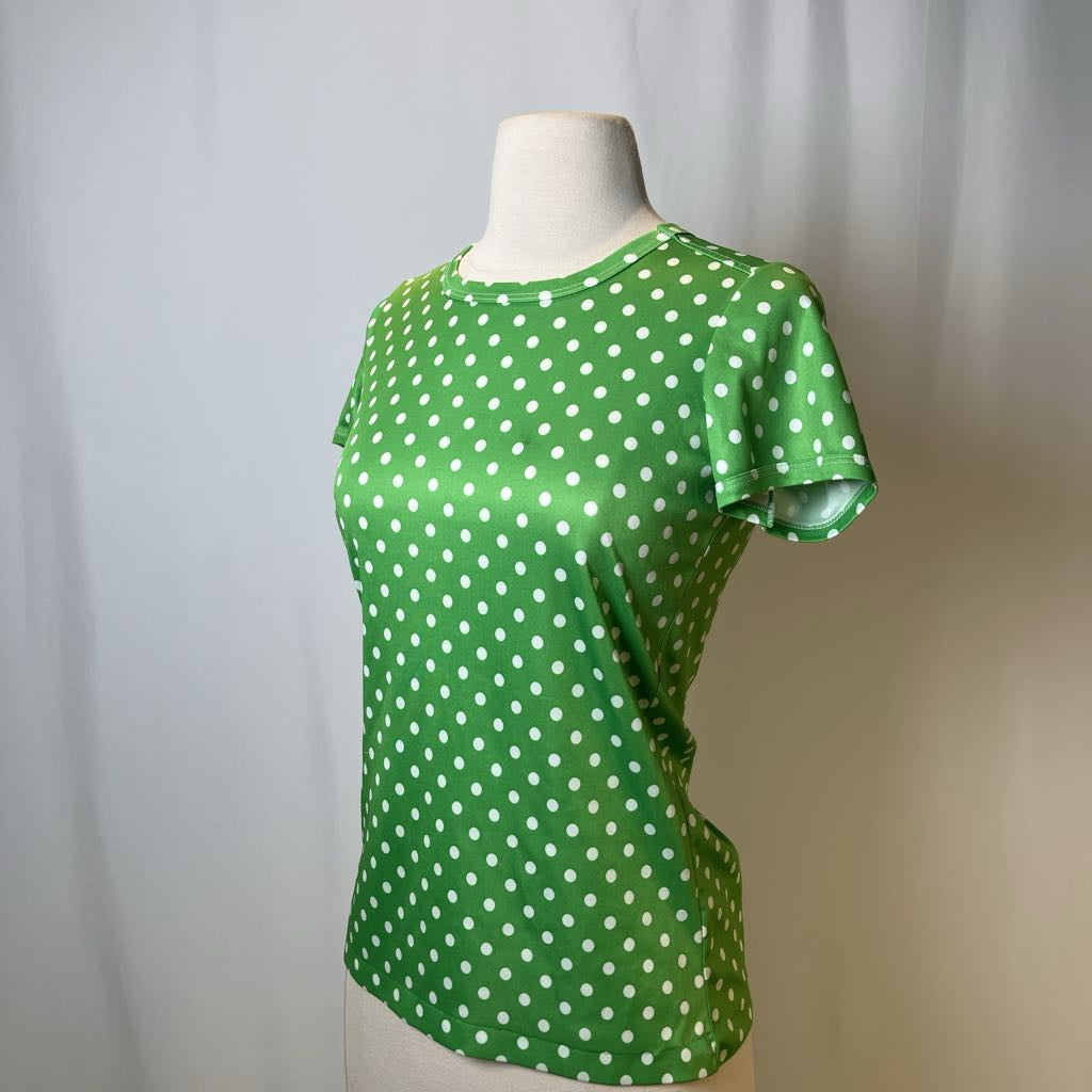 Green polka dot shirt on a mannequin against a plain background