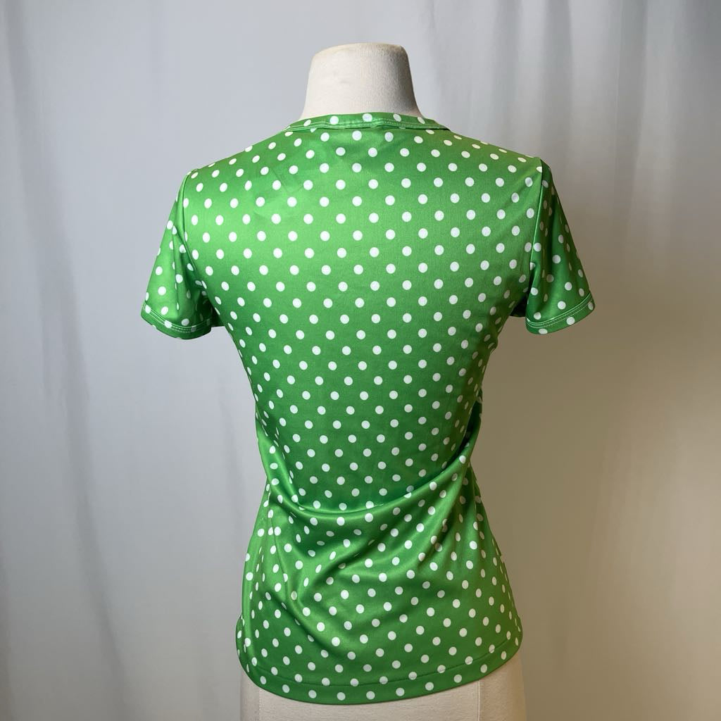Green polka dot shirt on a mannequin against a plain background