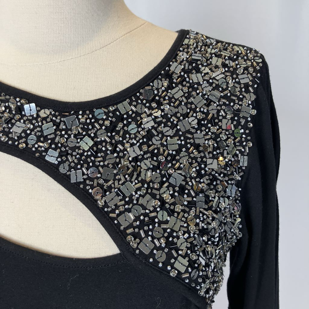 Black top with intricate beading on a mannequin against a white background