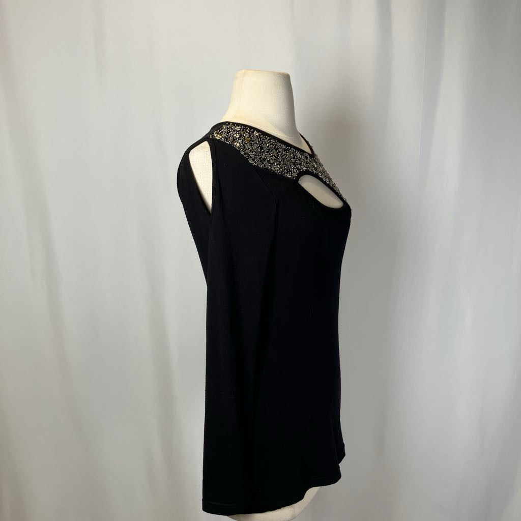 Black top with beading and a cutout on the chest against a white background. 