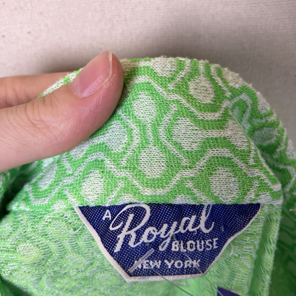 Green fabric with a 'Royal Blouse New York' label on a neutral background