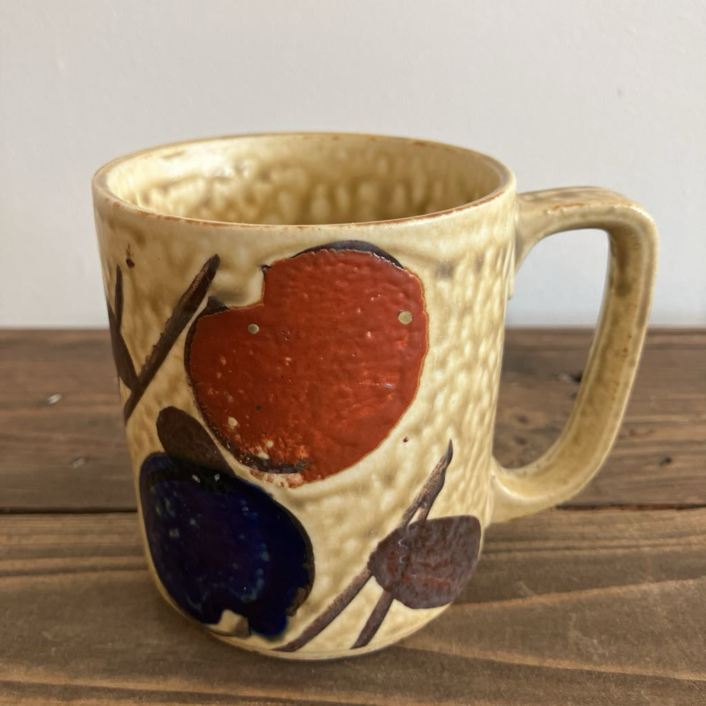 Ceramic mug with artistic spot designs on a wooden surface