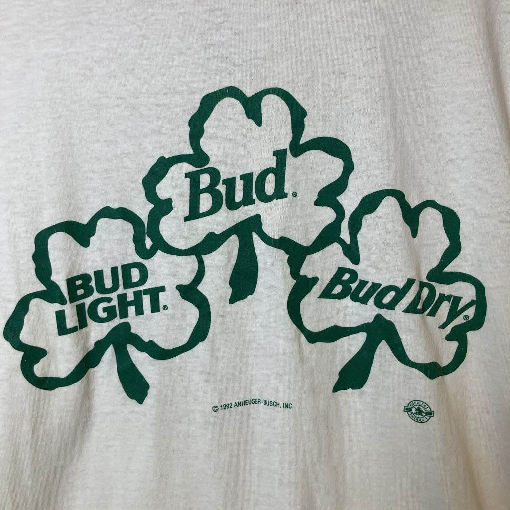 White sweatshirt with green shamrock logos for Bud Light and Bud Dry on a white background