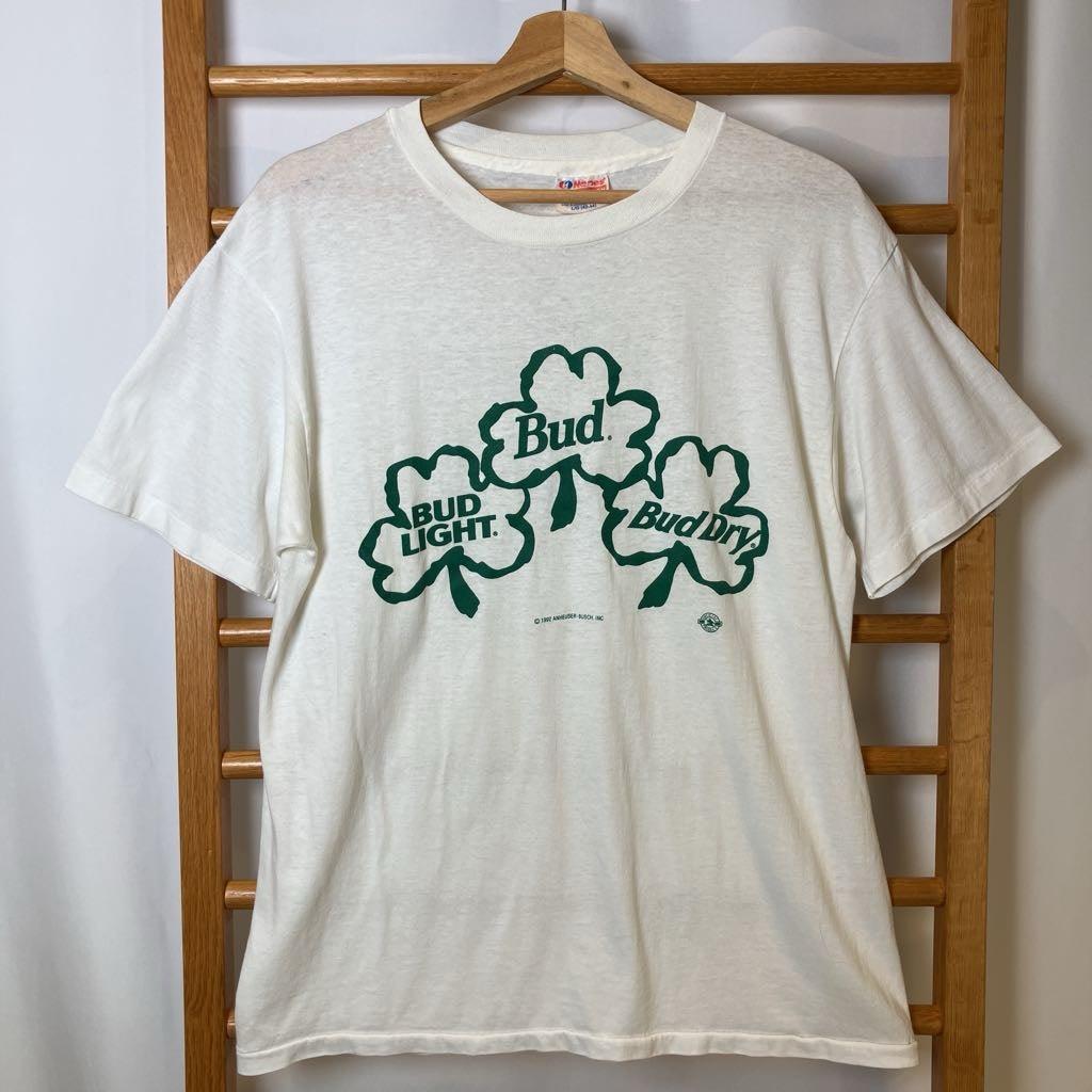 White t-shirt with green Bud Light logo on a wooden rack