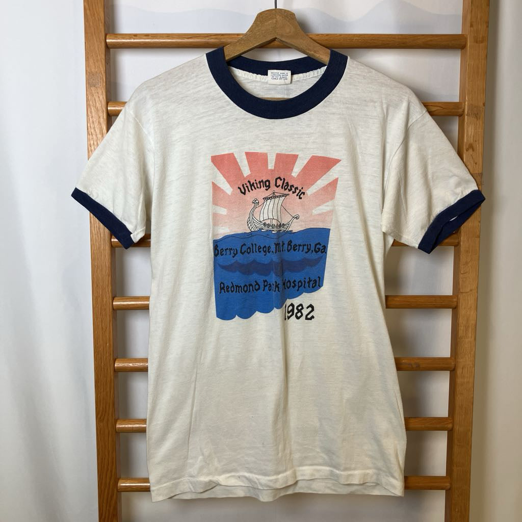Vintage t-shirt with graphic design on a wooden rack