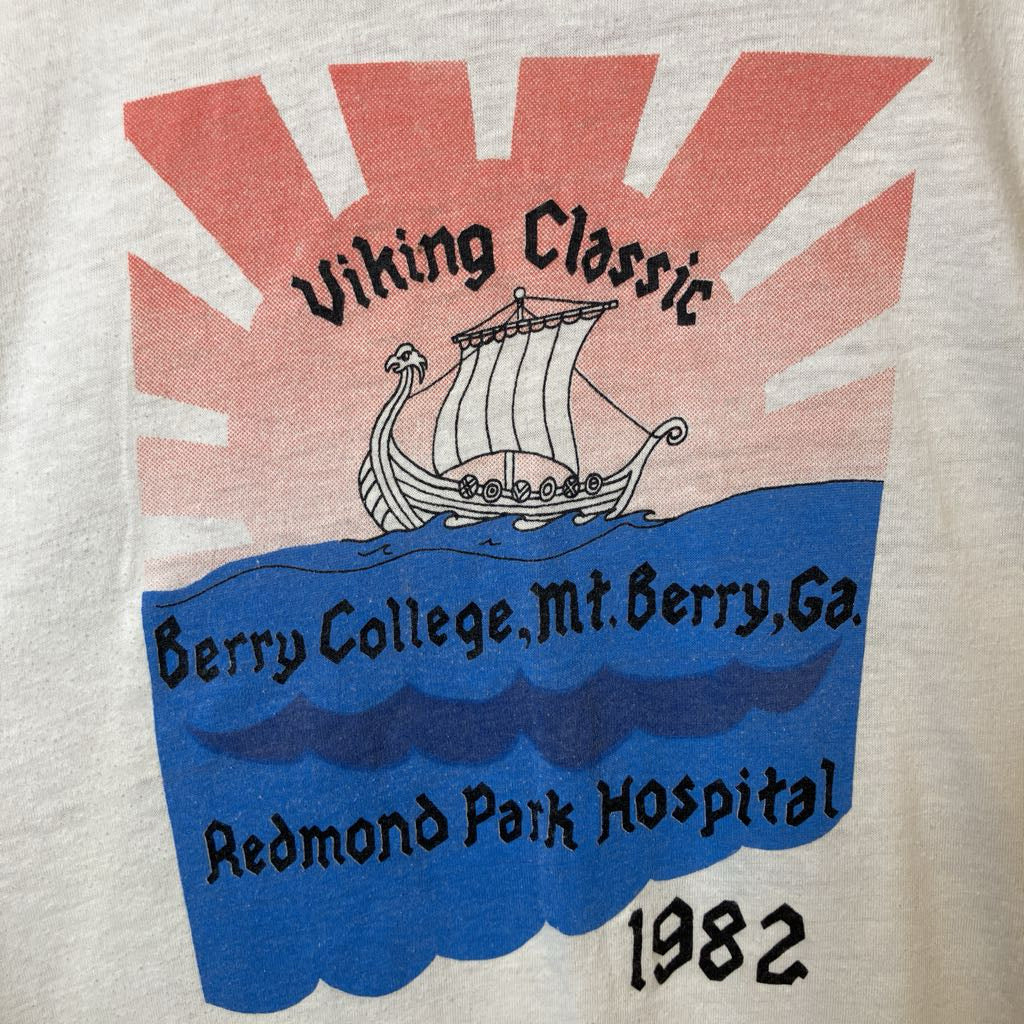 Vintage t-shirt with Viking ship design and text on a beige background