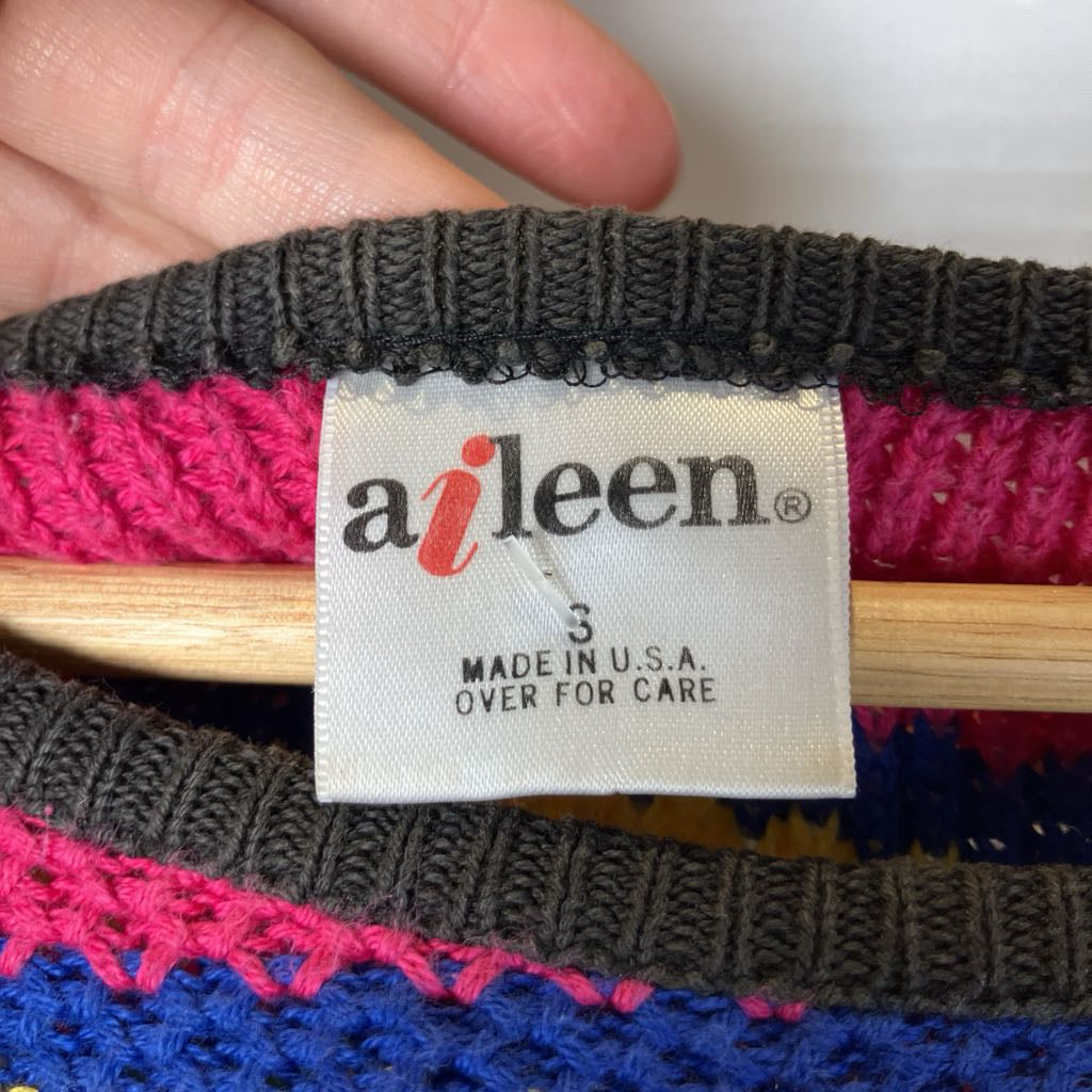 Colorful knitted item with 'aileen' label on a white background