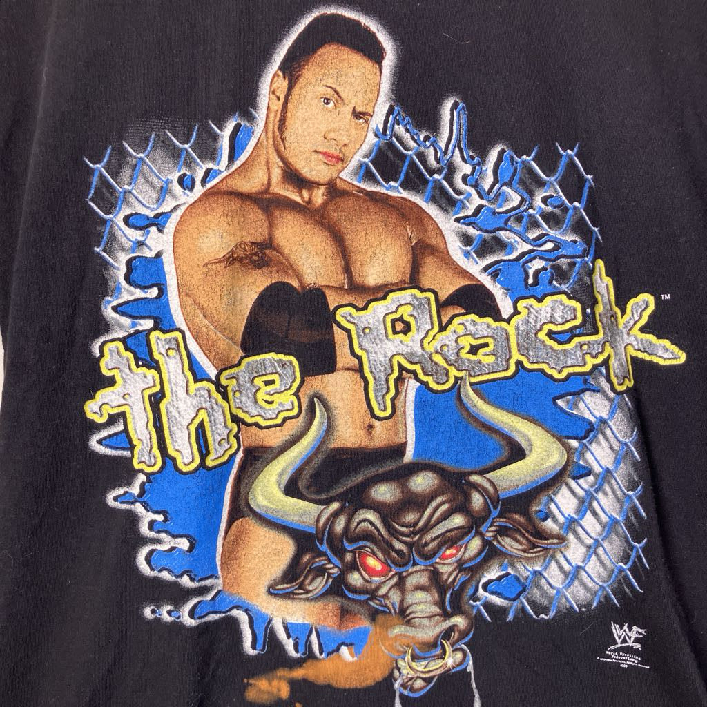 T-shirt with a graphic of a wrestler and a dragon, featuring the text 'The Rock'.