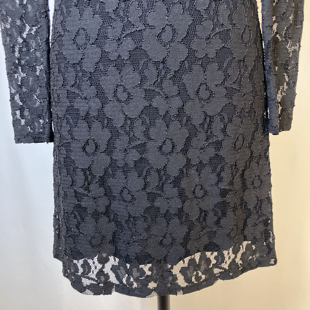 Black lace dress on a mannequin against a neutral background