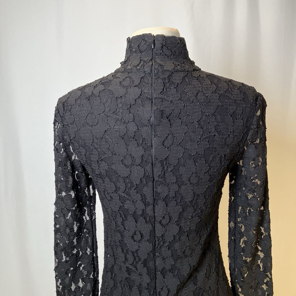Black lace dress on a mannequin against a neutral background