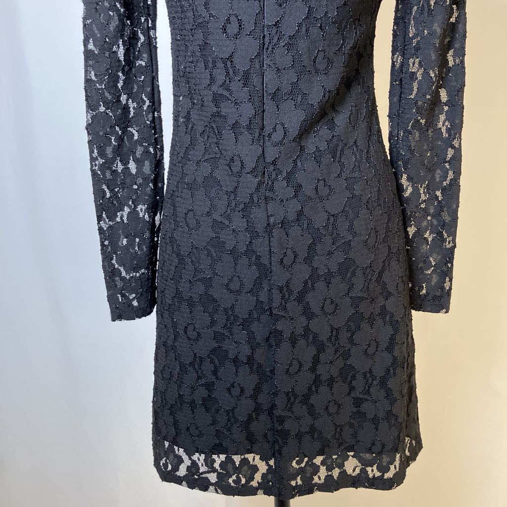 Black lace dress on a mannequin against a neutral background