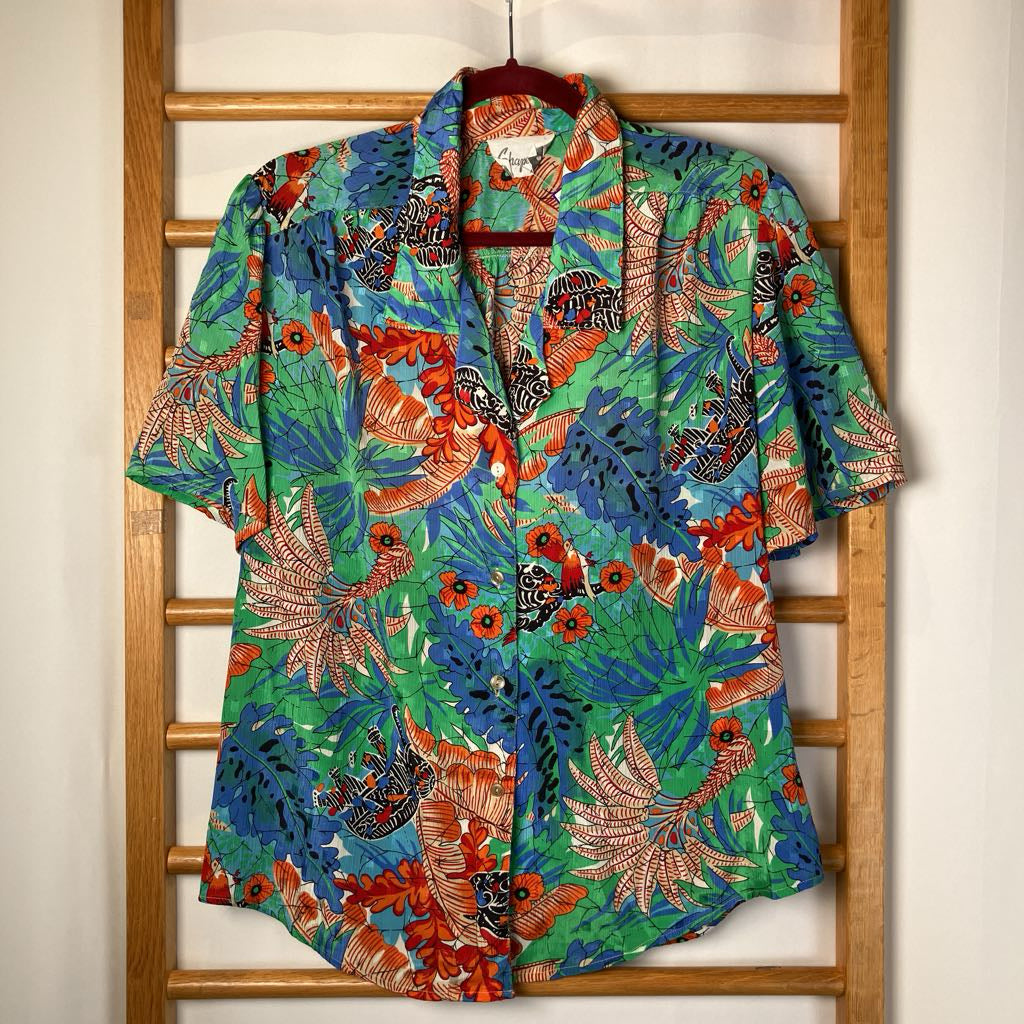 Colorful tropical shirt with floral pattern on a wooden rack