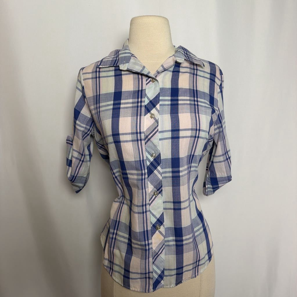 Blue and white plaid button-up shirt on a mannequin against a white wall. 