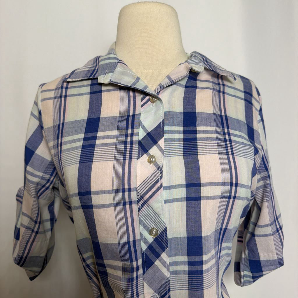 Blue and white plaid button-up shirt on a mannequin against a white wall. 