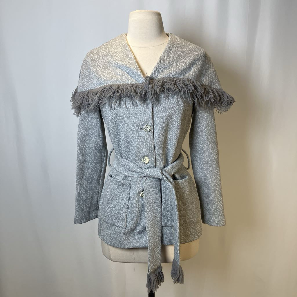 Gray coat with frayed edges on a mannequin against a plain background