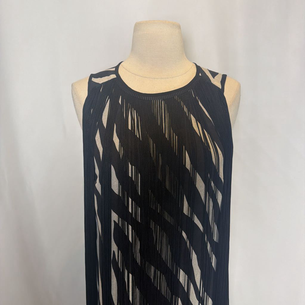 Zebra print dress with black fringe on a mannequin in front of a white wall. 