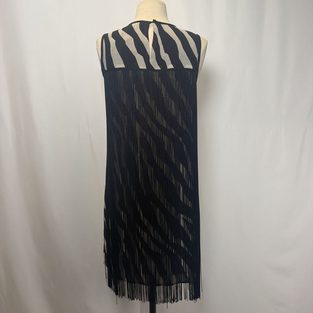 Zebra print dress with black fringe on a mannequin in front of a white wall. 