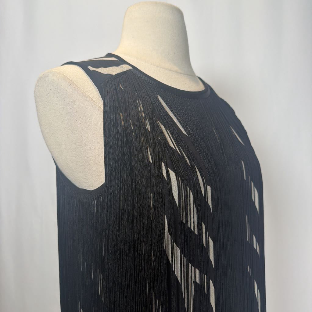 Zebra print dress with black fringe on a mannequin in front of a white wall. 