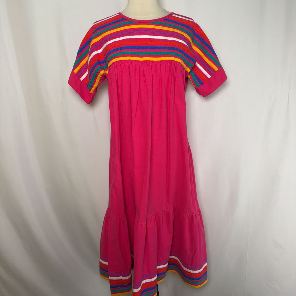 Pink ruffled maxi dress with striped design on a mannequin in front of a white wall. 